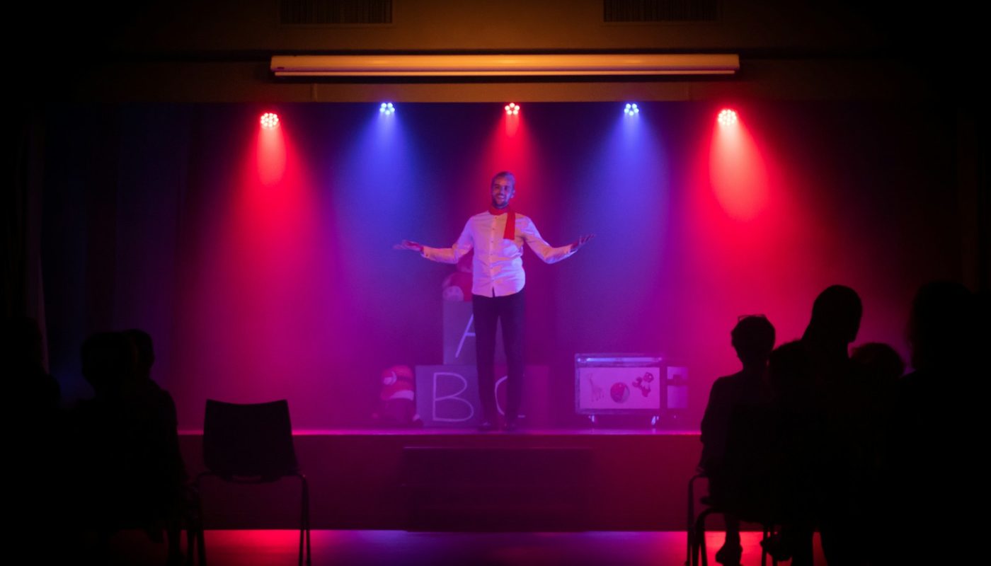 man in black shirt singing on stage
